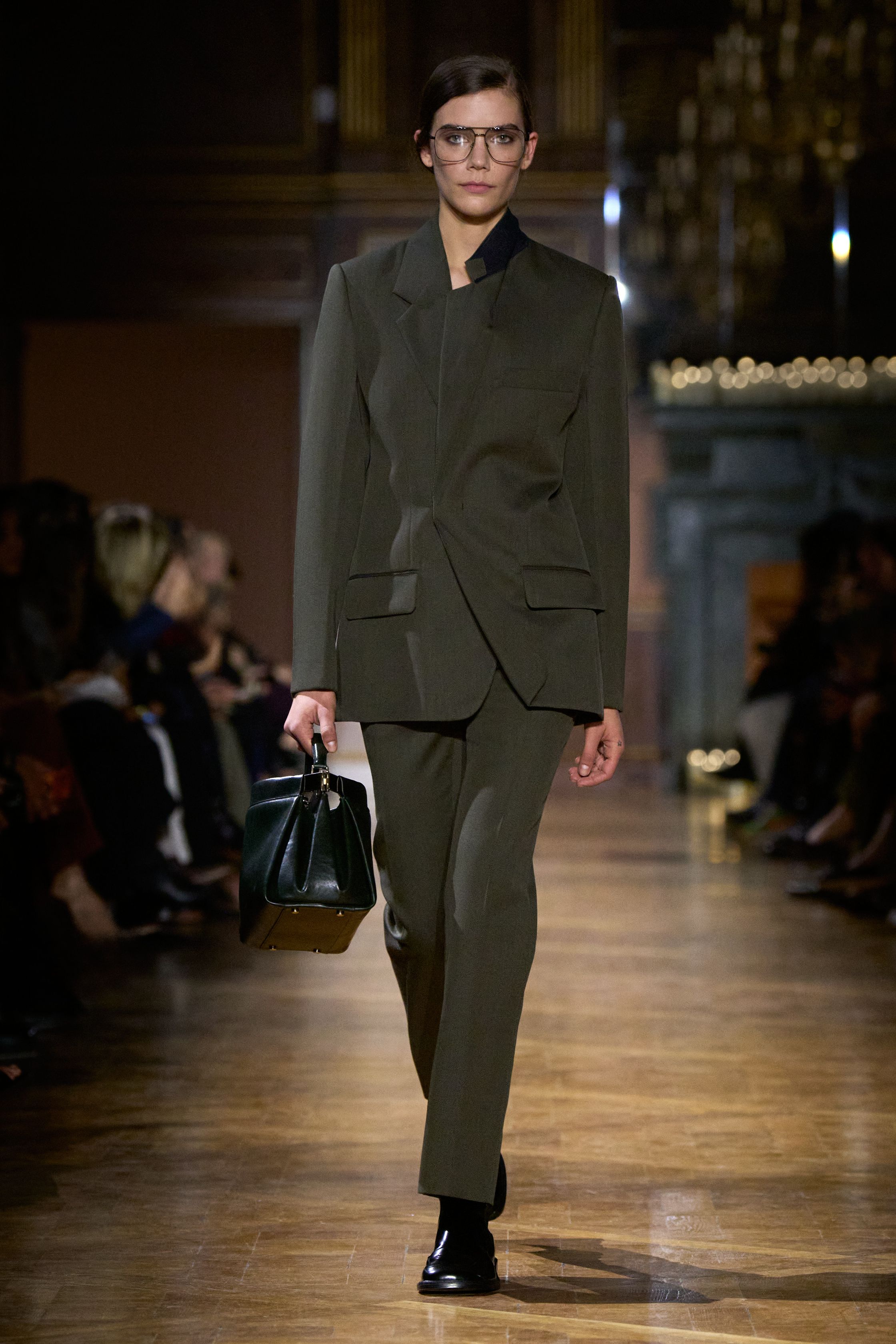Victoria Beckham 本季继续深化她的极简权力美学：干净利落的西装、精确比例的高腰裤与极具雕塑感的晚装礼服构建出一种冷静而优雅的都市女性形象。墨绿、深蓝与黑色构成成熟色谱，而球形裙摆与不对称剪裁让极简设计中出现微妙戏剧性。整场秀显得克制却高级-顽石频道趋势研究